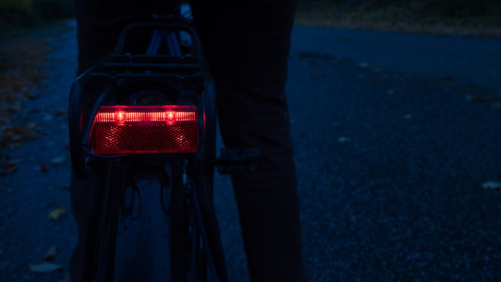 red bicycle bike rear light in the darkness, focus on rear light