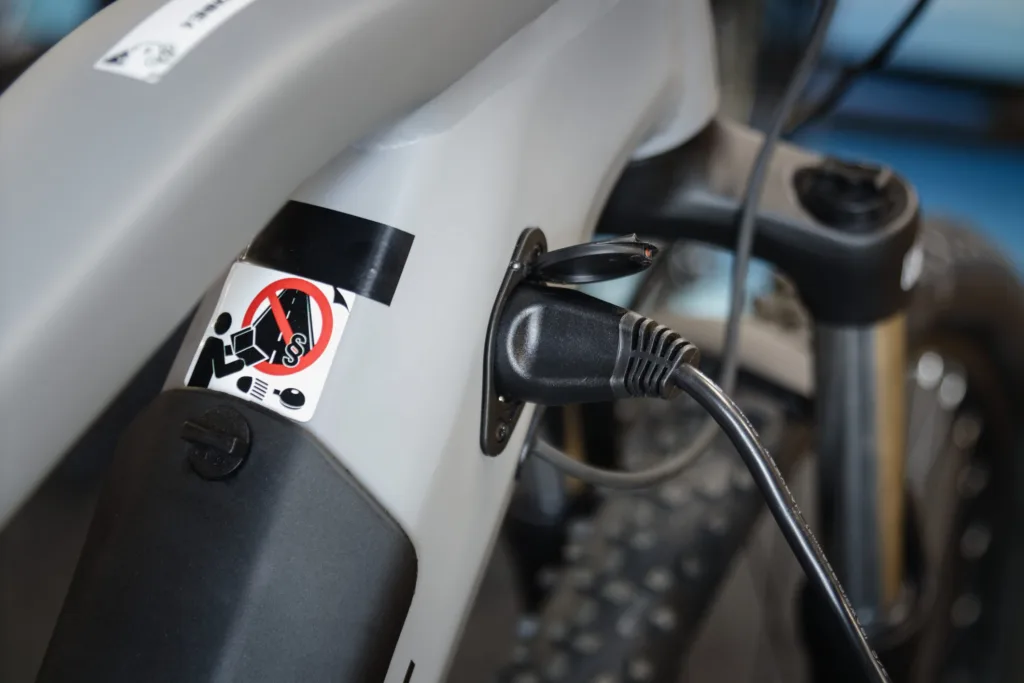 Close up shoto of electric bicycle during charging with charger plugged in