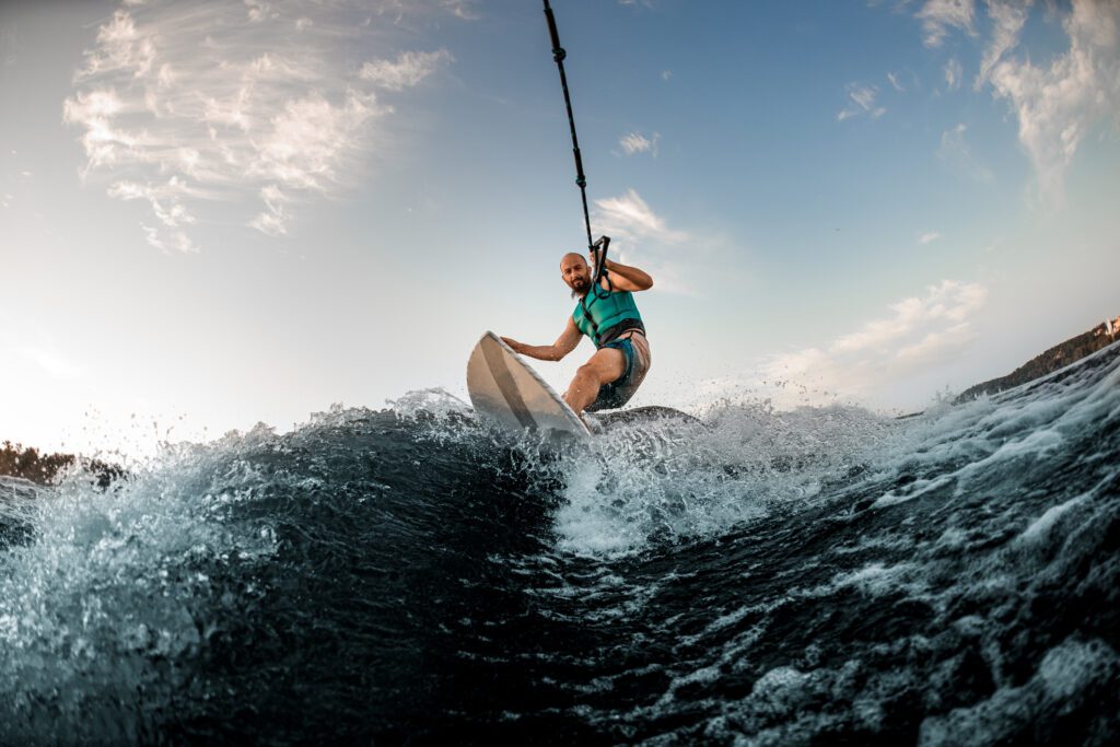 Front shot of man catching the wake while wakesurfing