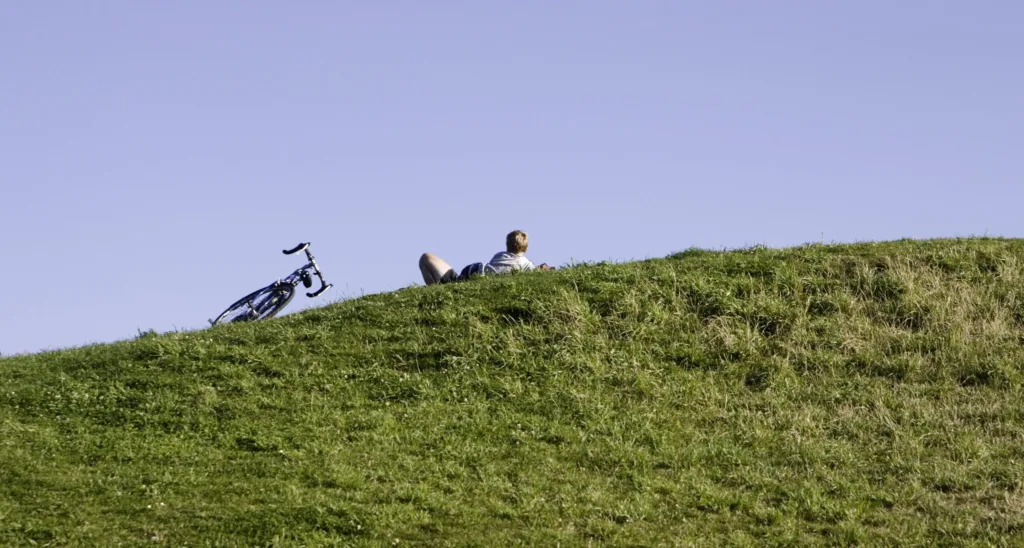 A person with a bike rests on a Seattle hill