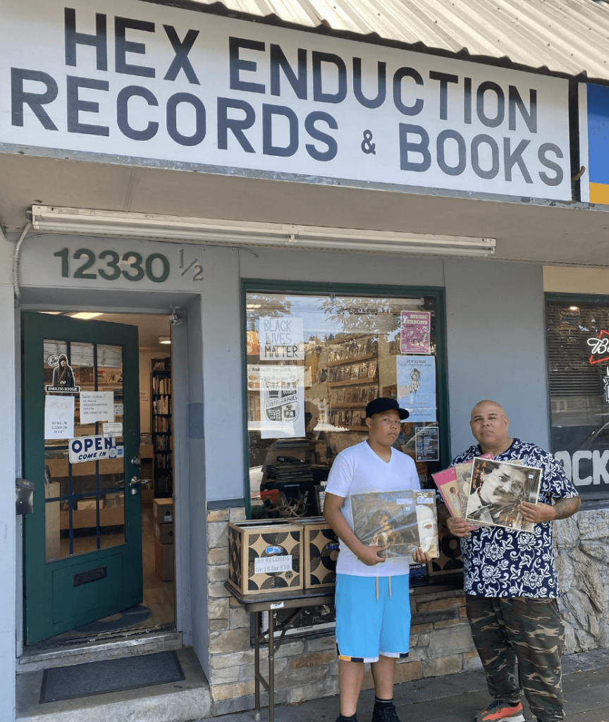 Supreme La Rock and his son outside Hex Enduction Records and Books