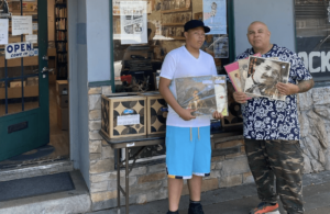 Supreme La Rock and his son outside Hex Enduction Records and Books