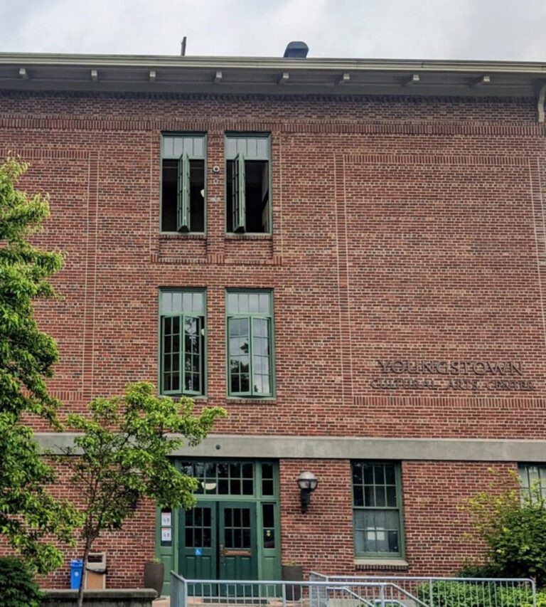 Youngstown-Cultural-Arts-Center-1536x960_cropped A large cultural center made of brick with a nice tree in front