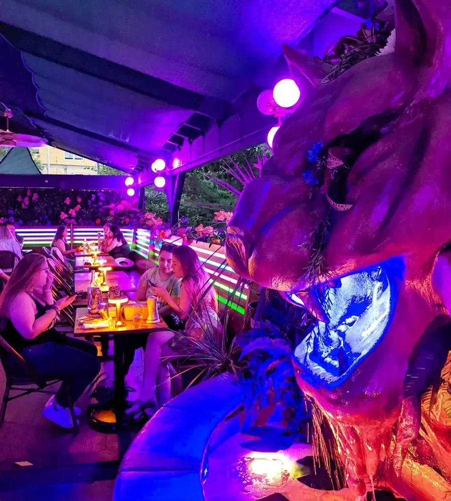 Patrons sit in the psychedelically-purple-lit patio bar at Dreamland