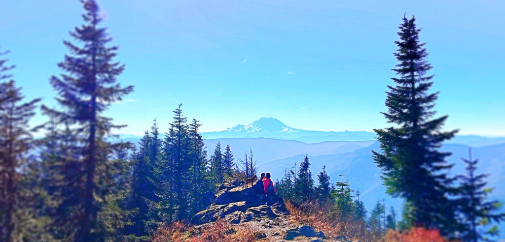 A couple pause for the view on a mid-autumn hike in the Cascade Foothills, near North Bend, Washington State.