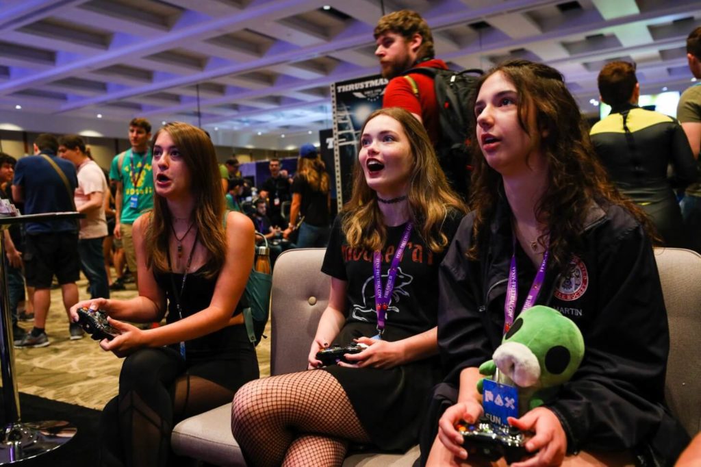 A group of people play video games at the PAX West convention