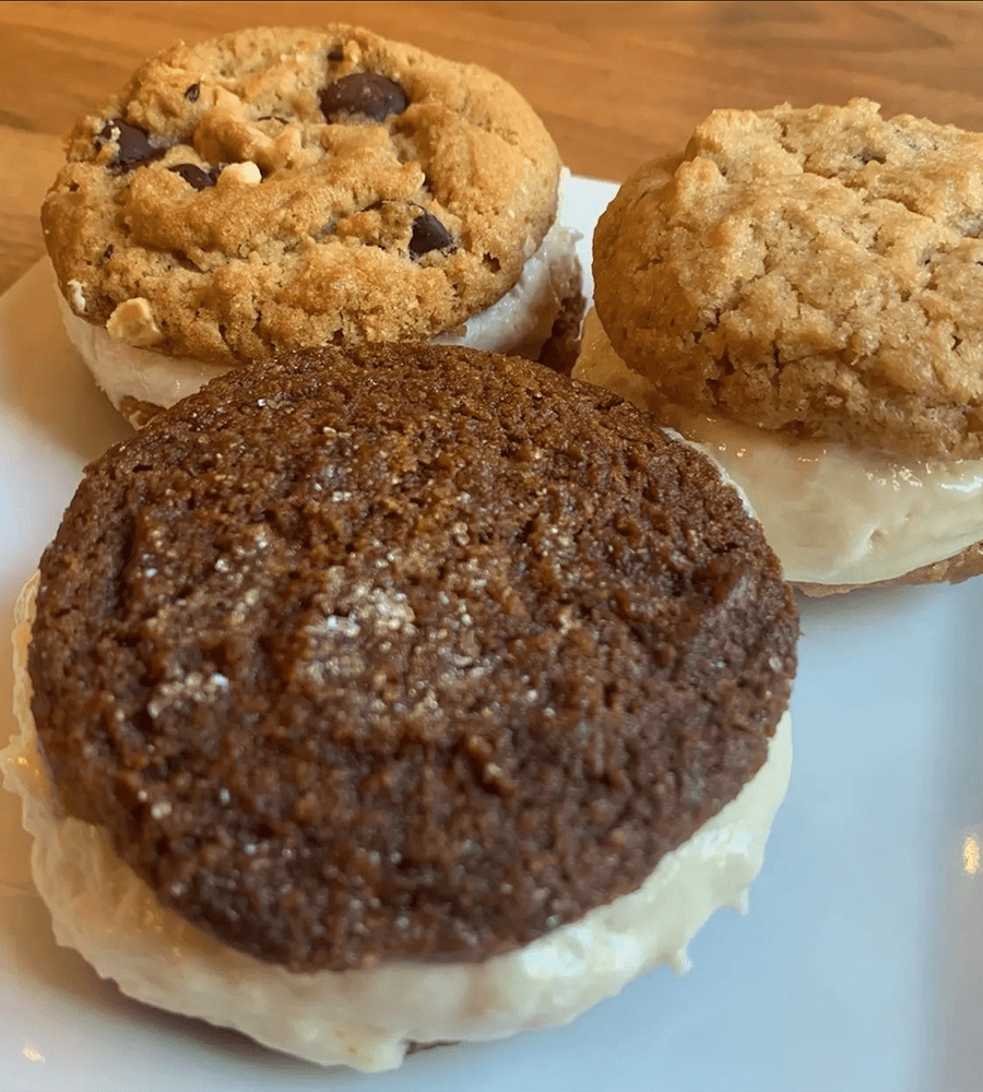 A plate of three cookies with cream filling at Flying Apron Bakery