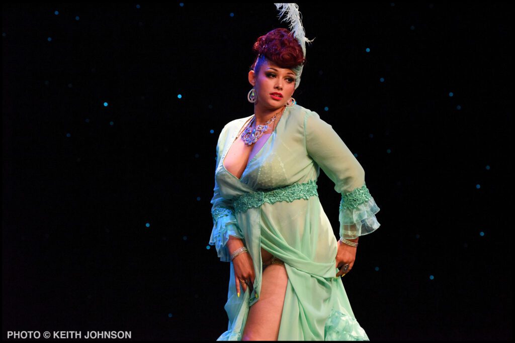 A performer performs at last year's What the Funk?! burlesque show wearing a mint green robe and feather