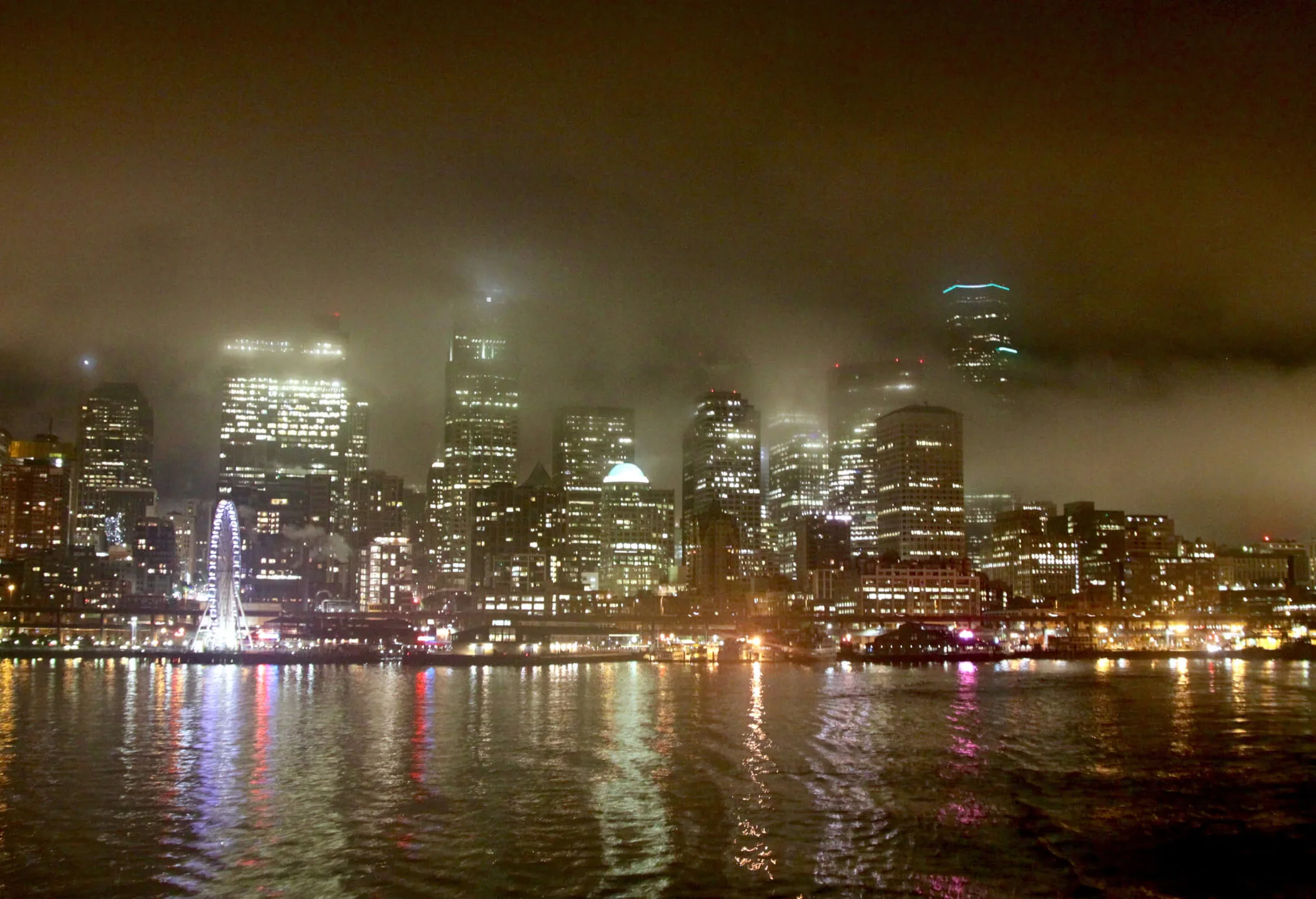 A nighttime shot of the Seattle waterfront in the low lying fog