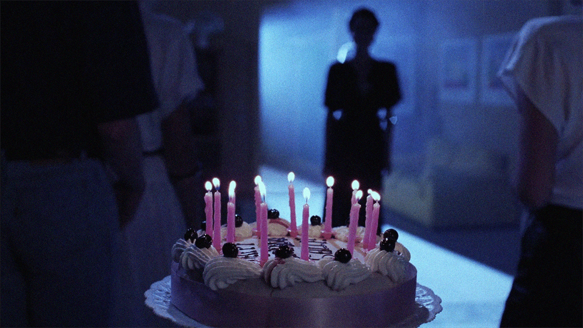 Demons 2 screencap of lit birthday cake in dimly lit room