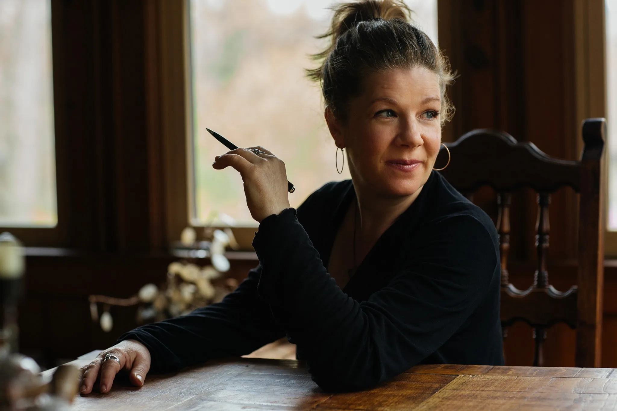Dar Williams sitting at a desk with a pen in hand.