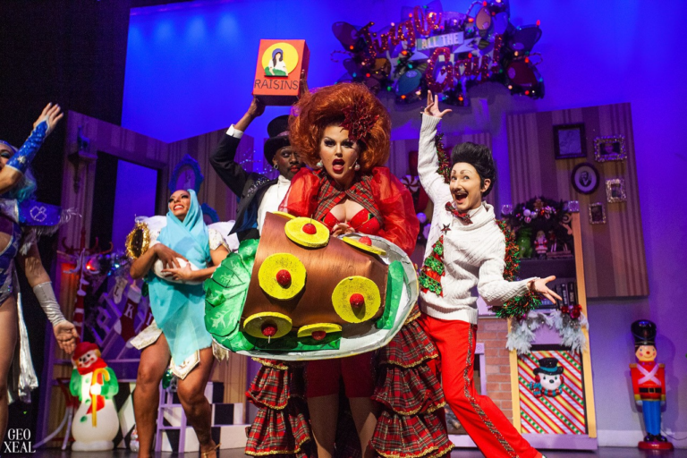 A colorful cabaret cast holds up a giant stuffed turkey toward the camera. An ornate holiday scene