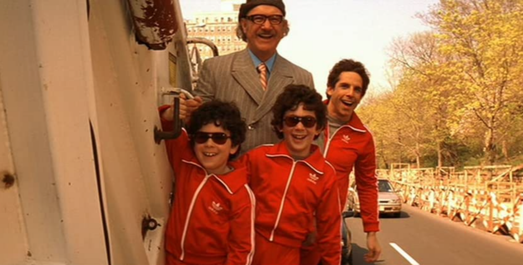 Chas, and his sons Ari and Uzi, ride a garbage truck, grinning with their grandfather, Royal Tenenbaum.