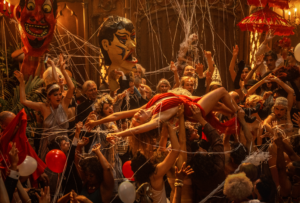 Margot Robbie crowd-surfs on her back through an extravagant, raucous crowd