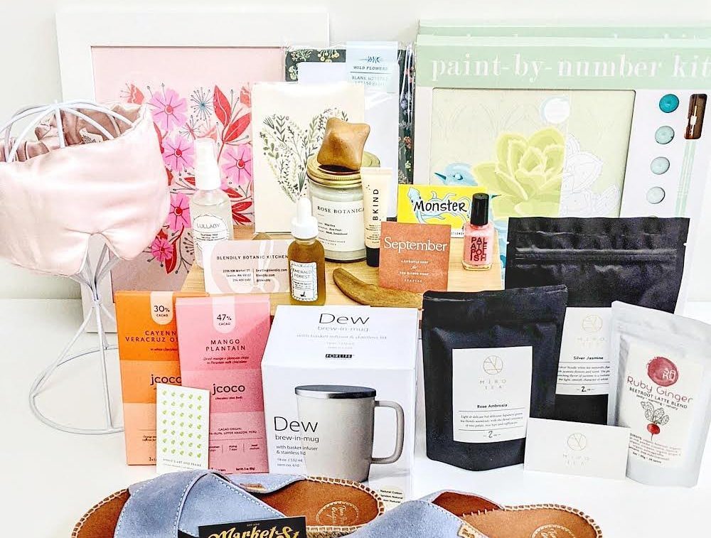A spread of gifts from Monster. There are slippers, a brew mug, tea, candles, oils, a paint-by-number kit, and more