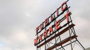 A shot of the Pike Place Market sign from below against a cloudy sky.