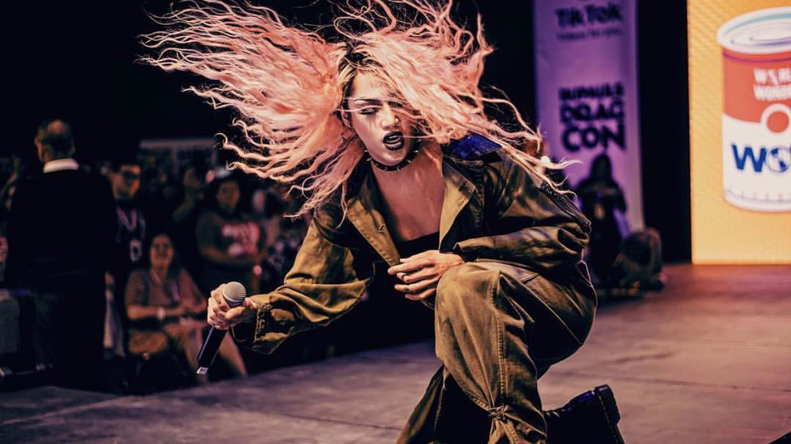 Adore DeLano performs on stage—pink, long hair thrashing behind her