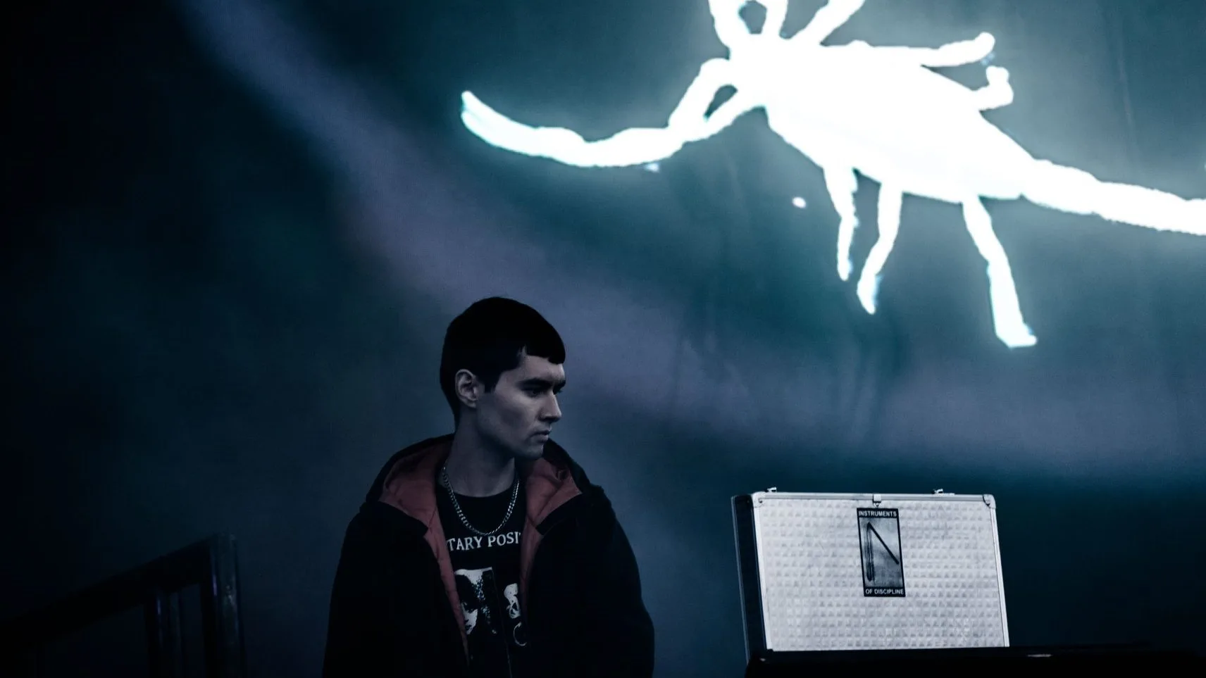 The artist Schacke against a dark gray background with a scorpion.