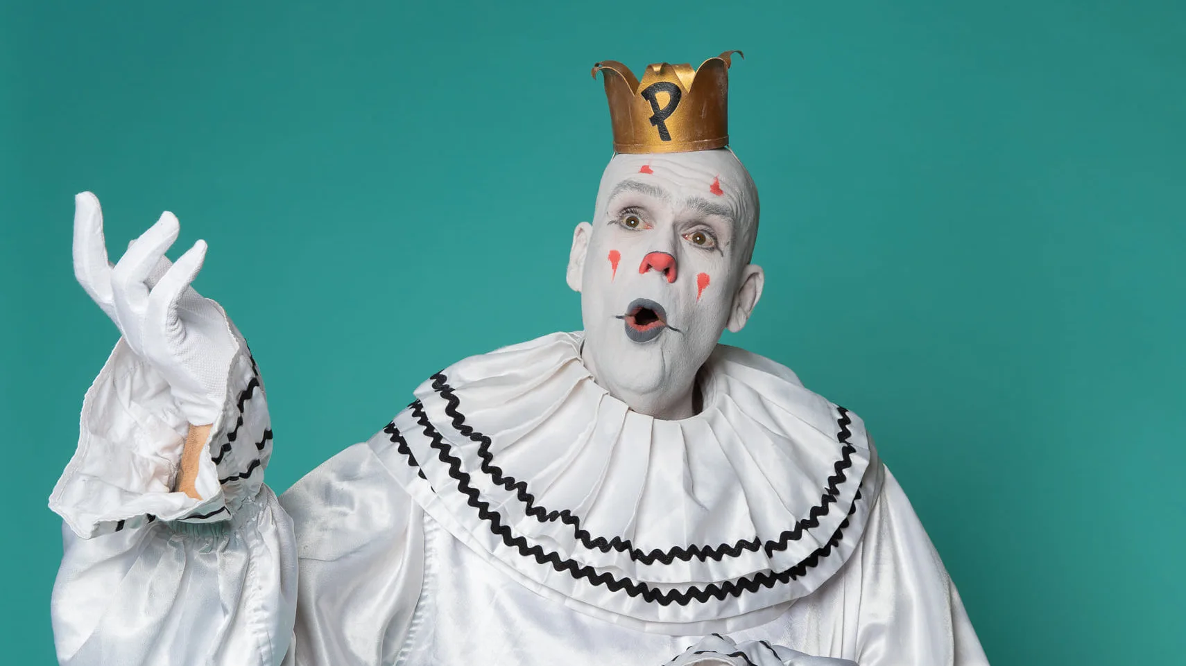 Puddles Pity Party poses against a teal background while singing