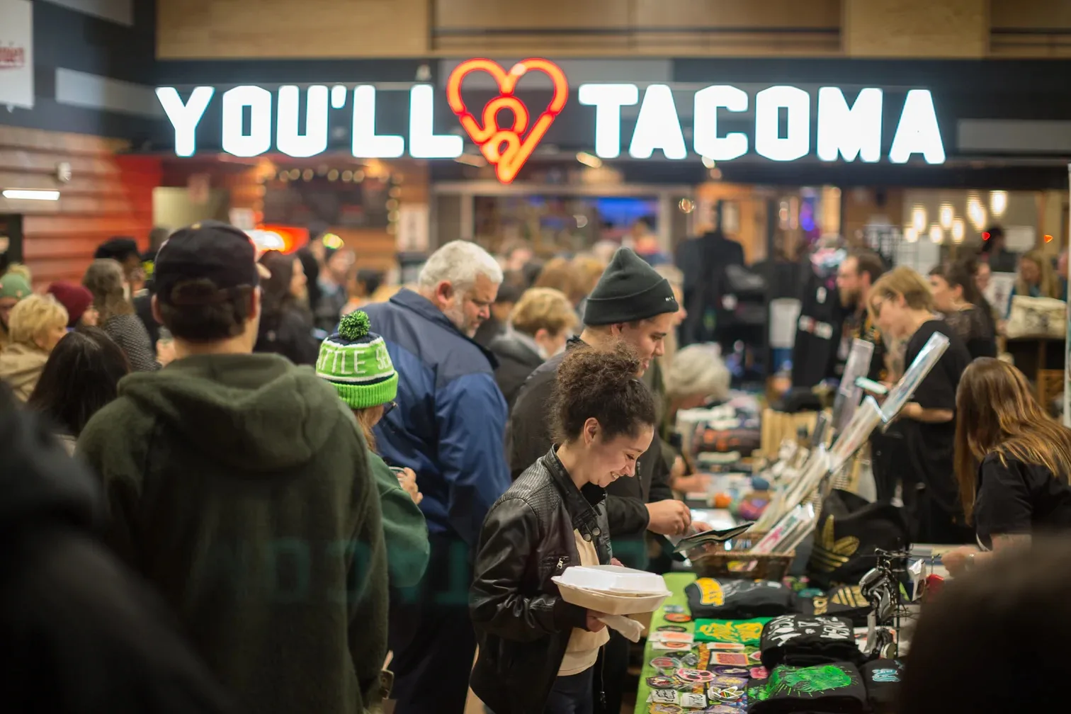 A crowd of people gather inside the Maritime Museum for a Tacoma Night Market