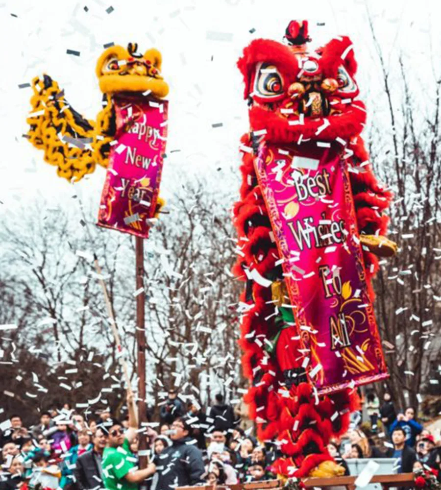 A crowd of people gather in Seattle Center for Vietnamese Lunar New Year. Lion puppets are raised above
