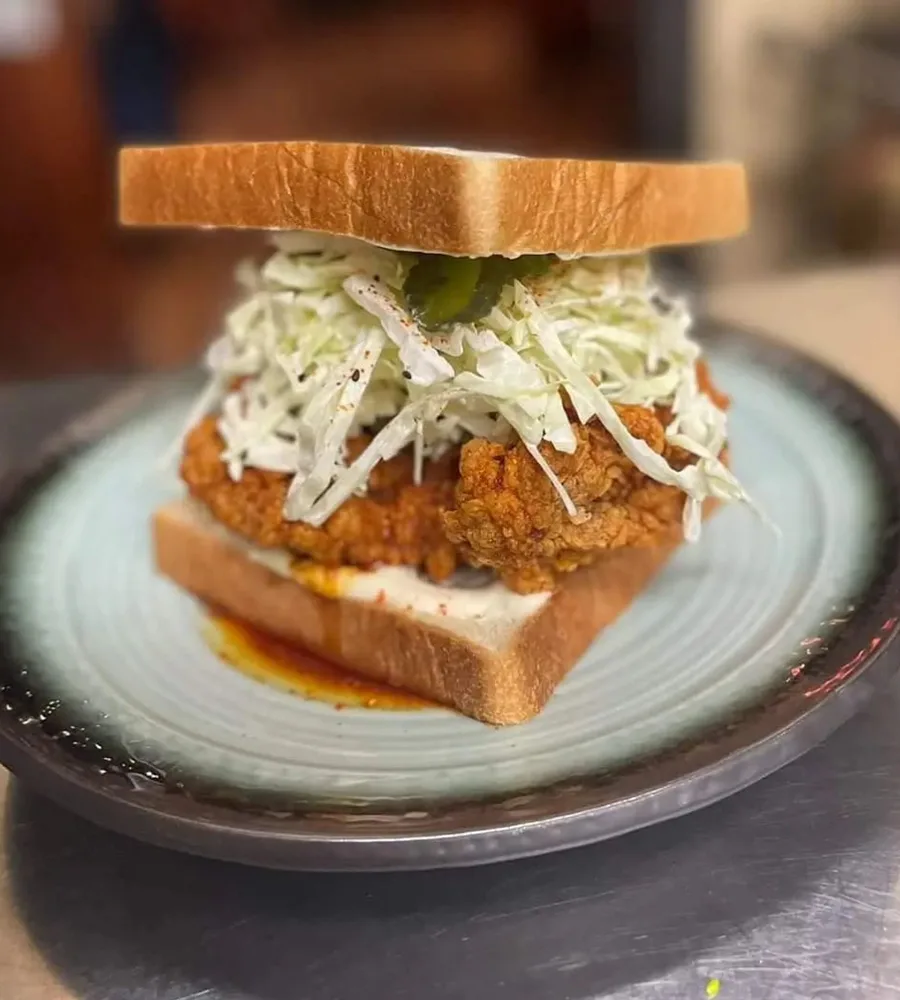 A chicken sando sits on a plate