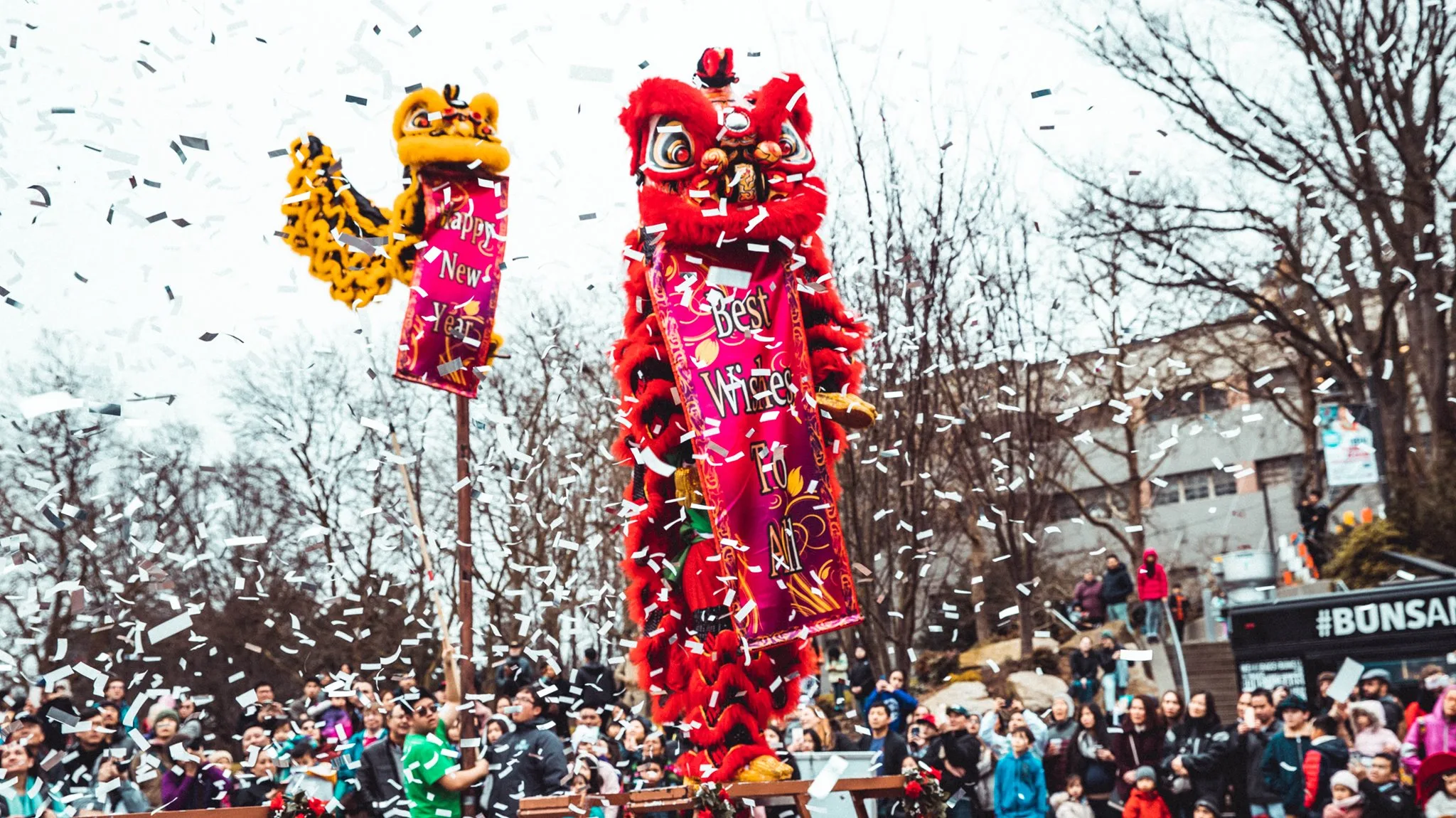 A crowd of people gather in Seattle Center for Vietnamese Lunar New Year. Lion puppets are raised above