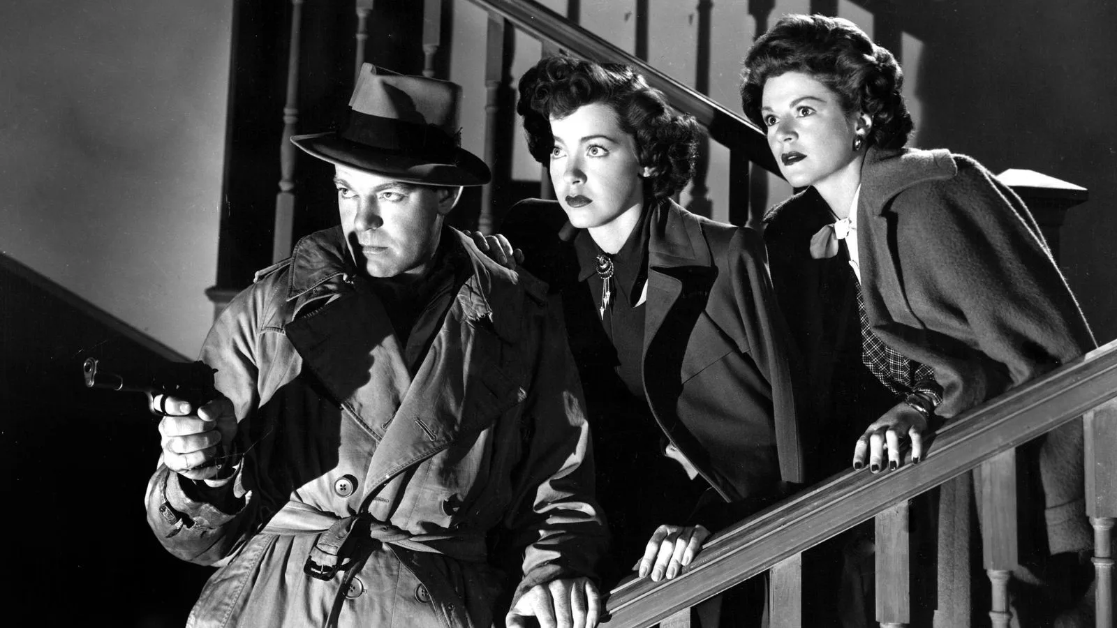 A screencap of three characters from Raw Deal decending a staircase in suspense.