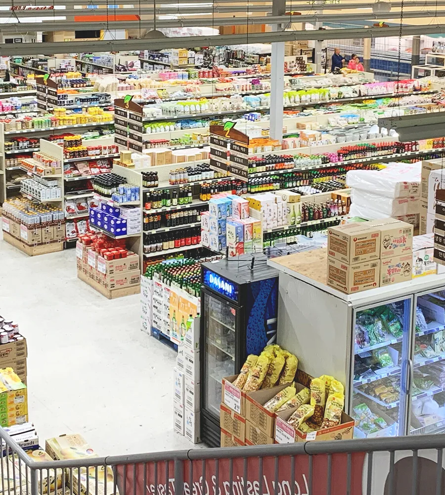 A view of the interior of G Mart from above. Rows upon rows of groceries stretch into the store.