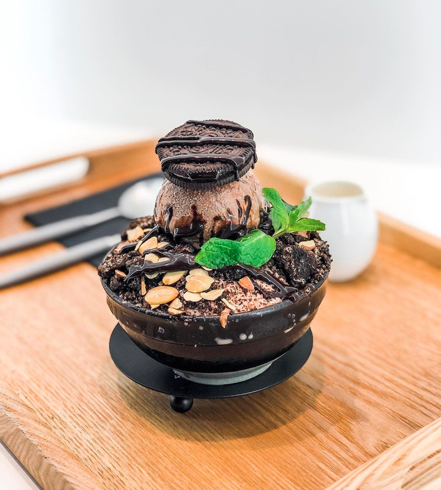 The oreo crunch bingsu from Lumi Dessert Cafe on a bamboo tray.