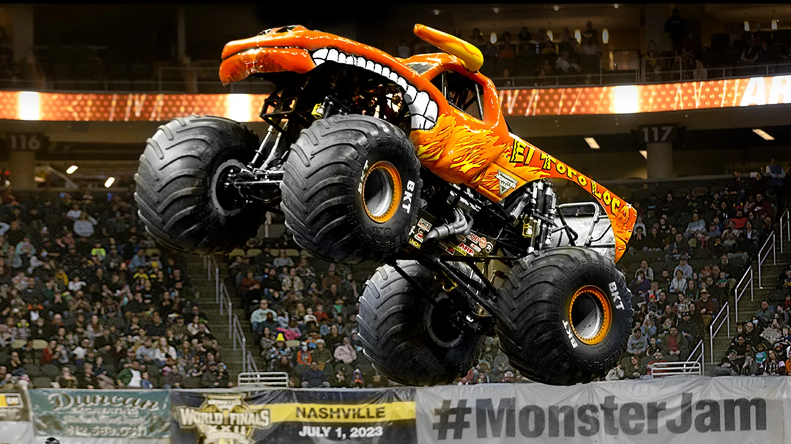 The El Toro Loco truck flies through the air at Monster Jam with a crowd in the background