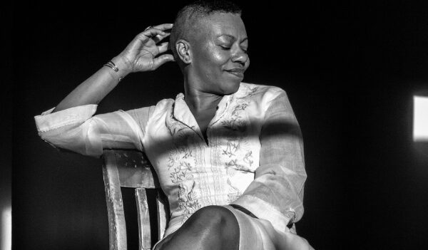 Poet and writer Anastacia Renee poses in a black and white image with her face off to one side, smiling