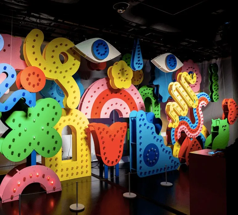 a wall of light-up colorful shapes all in primary colors. It feels like a circus or Vegas.