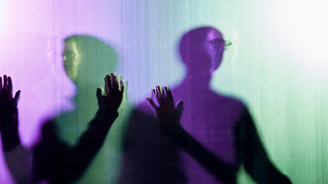 Chemical Brothers behind a purple- and green-lit screen