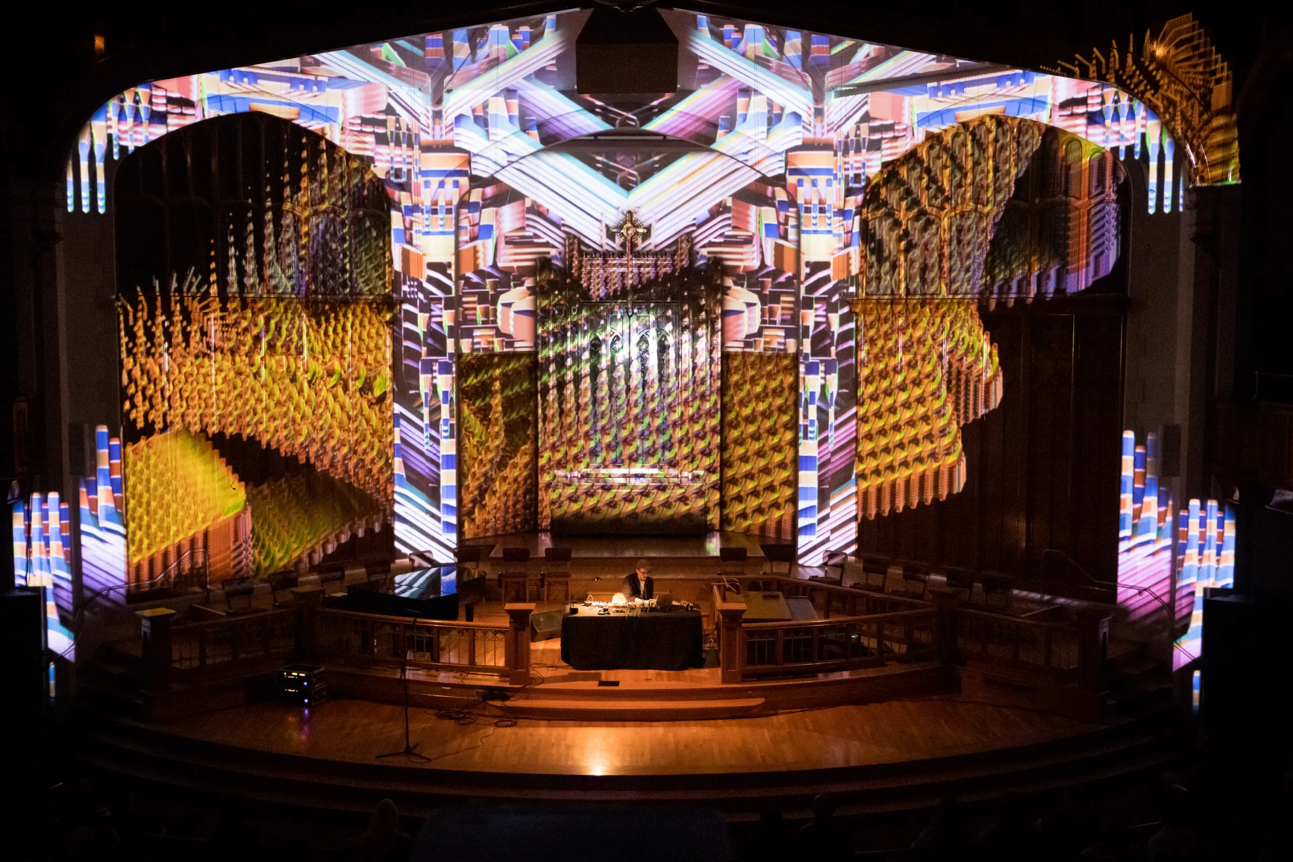 Suzanne Ciani performing while a psychedelic light display shines on the ceiling