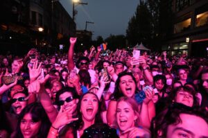 A happy, pink-lit crowd at Capitol Hill Block Party