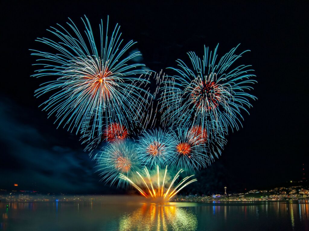 Huge, vibrant fireworks illuminate a dark sky on Lake Union during Seafair on the Fourth of July