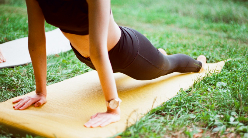 A person performs yoga in the park