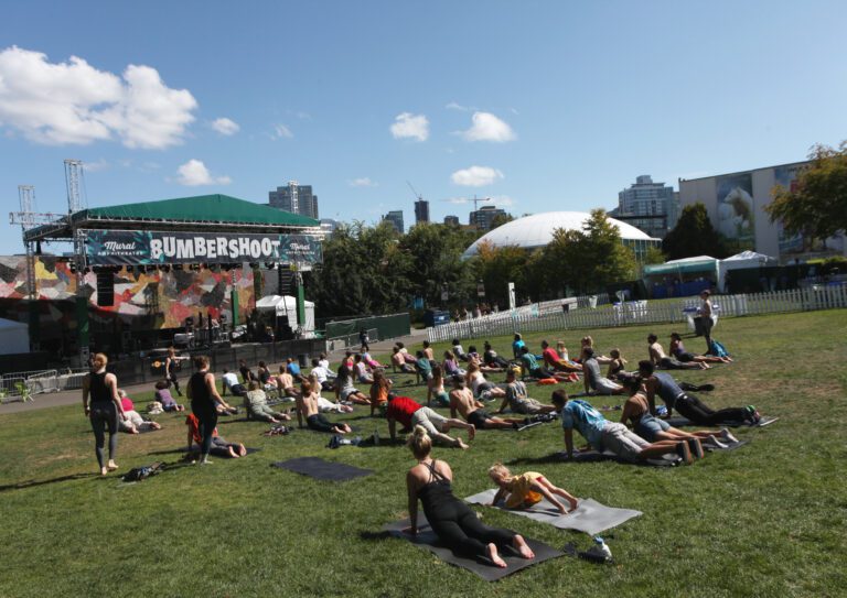 A group of people doing yoga stretch out at Bumbershoot