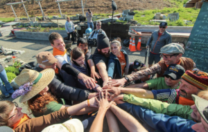 A group of gardeners put their hands in the middle for a cheer