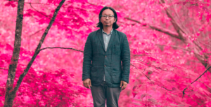 Tomo Nakayama stands in an edited field of sakura-pink trees.
