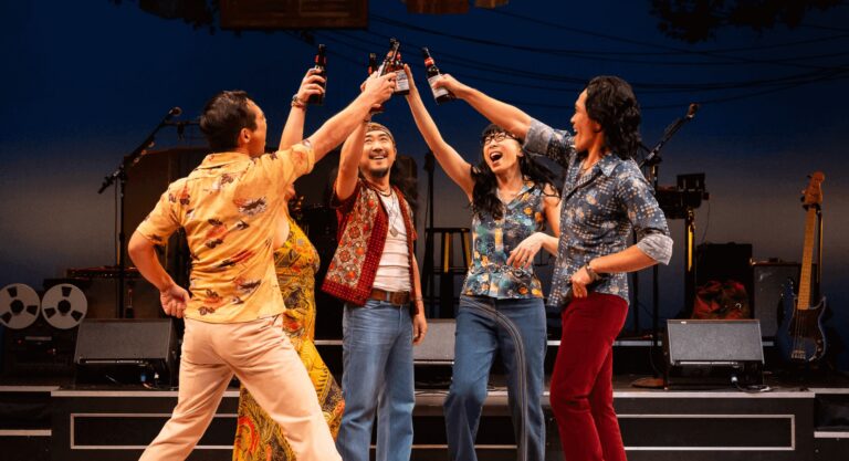 A group of actors clink beers in a cheers in the musical CAMBODIAN ROCK BAND.