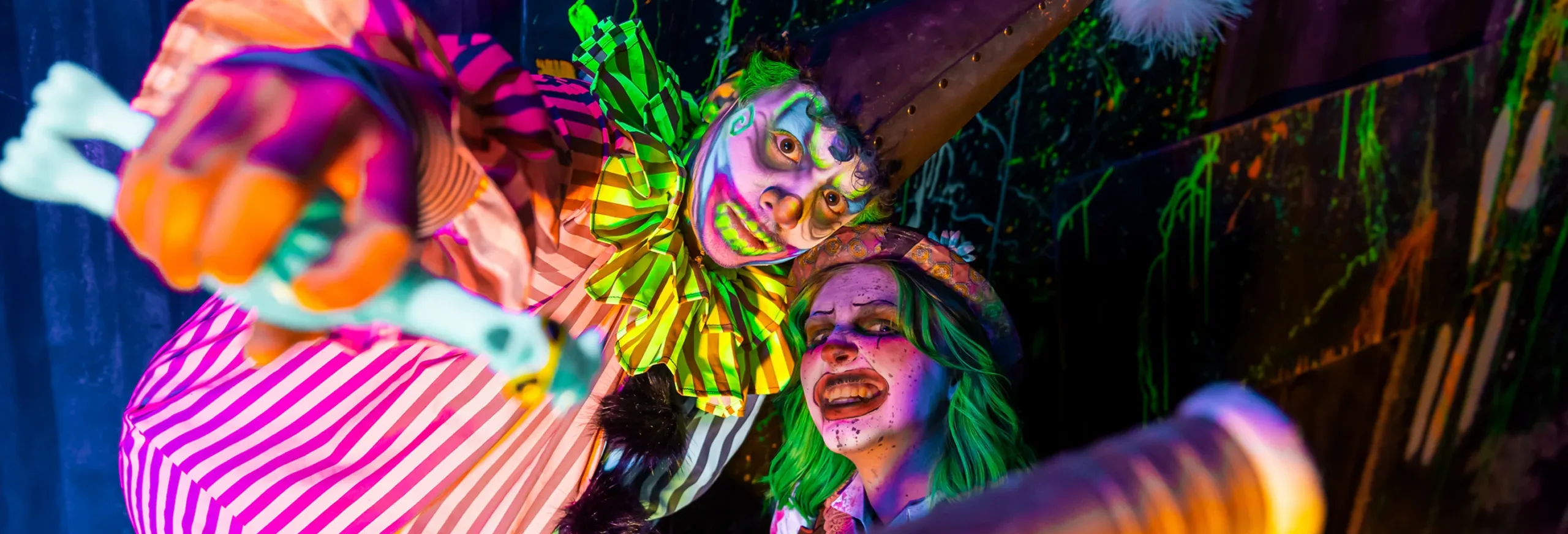 Two psychedelic clowns look at the camera.