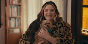 Actress Megan Stalter holds a little dog in a still from the upcoming moving Cora Bora.