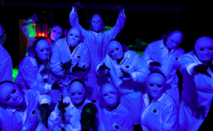 A crew of masked Chocolate workers in a blue lighting