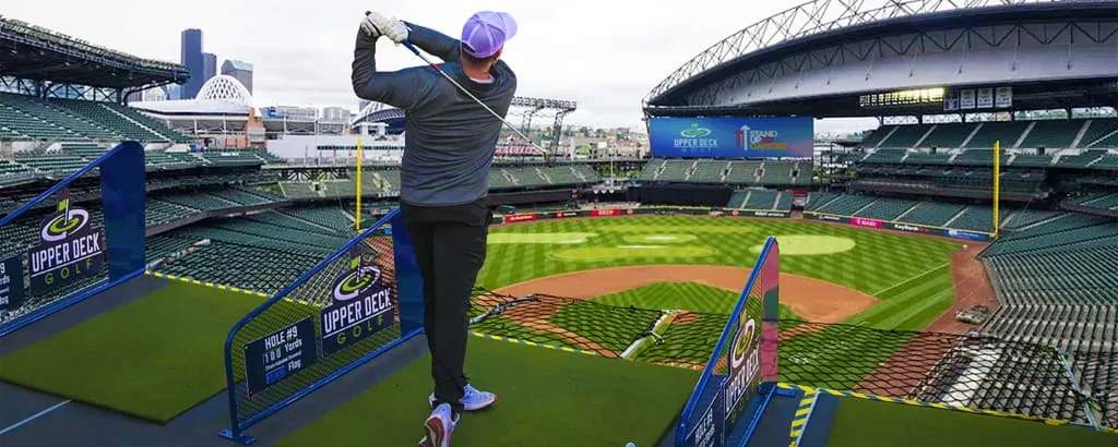 A man plays golf at the top of T-Mobile Park.