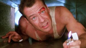 Actor Bruce Willis crawls through a crawling space while performing in the movie Die Hard.