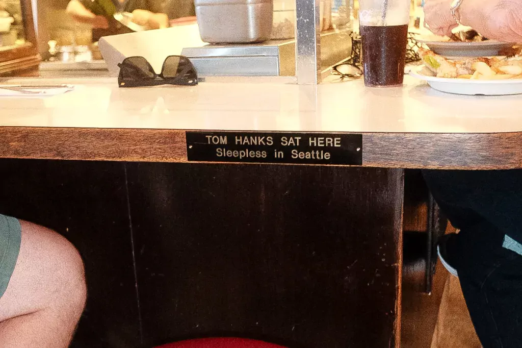A seat at Athenian with a plaque reading "TOM HANKS SAT HERE"