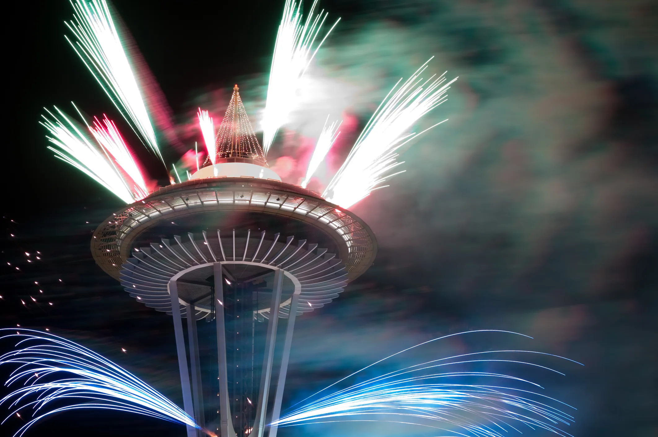 Seattle Space Needle illuminated by fireworks at midnight on New Years Eve.