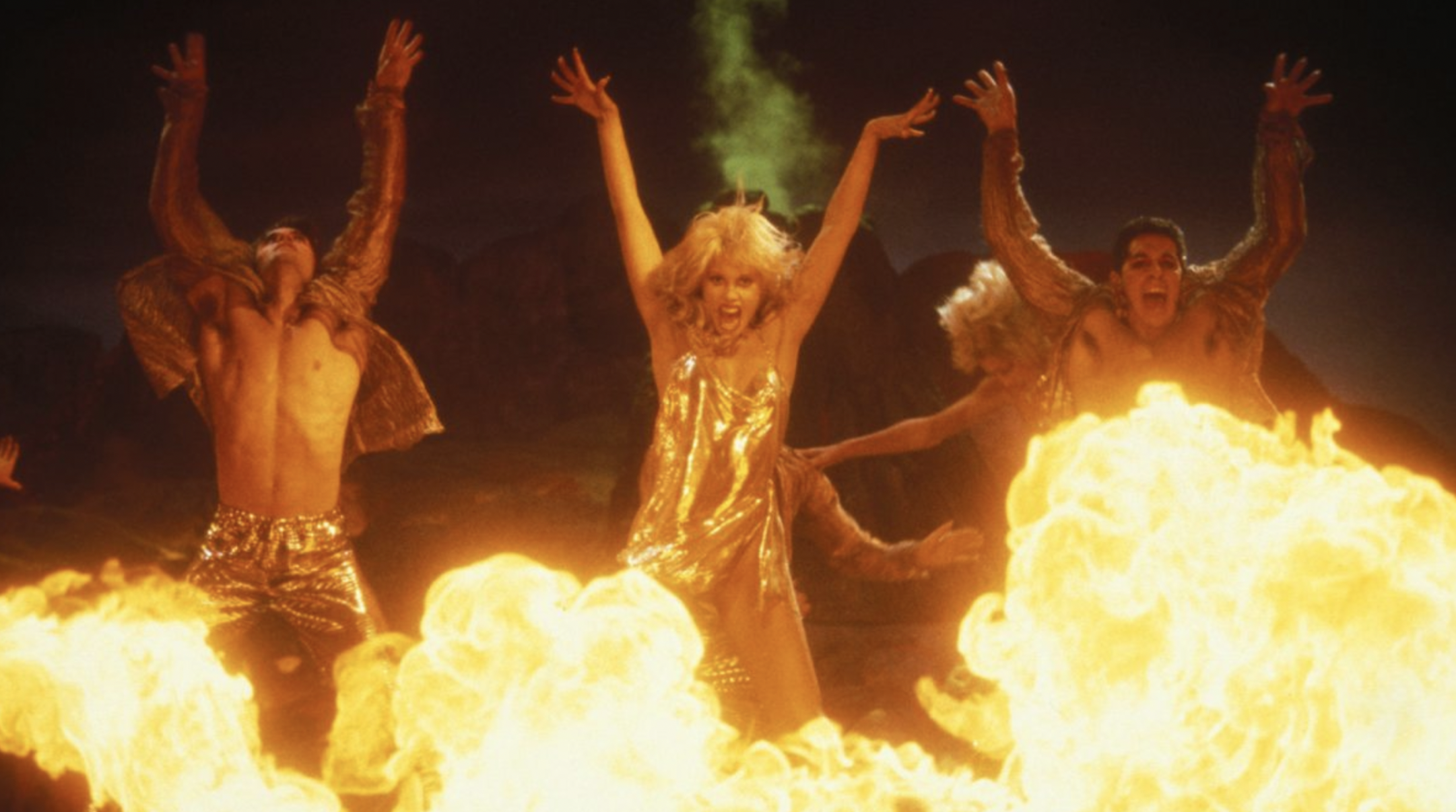 Three dancers jump and lunge over fire in the movie Showgirls